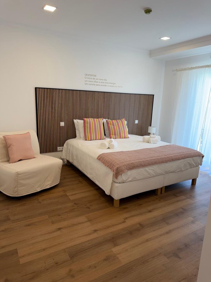 Quarto Despertar com cama ampla, poltrona e luz natural